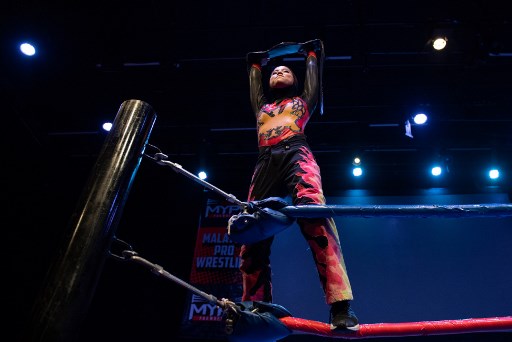 This picture taken on July 6, 2019 shows the hijab-wearing Malaysian wrestler known as Nor “Phoenix” Diana holding the Wrestlecon championship belt after winning a match against male opponents organised by Malaysia Pro Wrestling in Kuala Lumpur. – A hijab-wearing, diminutive Malaysian wrestler known as “Phoenix” cuts an unusual figure in the ring, a female Muslim fighter taking on hulking opponents in a male-dominated world. (Photo by Mohd RASFAN / AFP) / TO GO WITH Malaysia-wrestling-religion-Islam, FEATURE by Patrick LEE