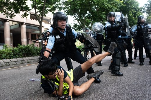 A photojournalist falls down during clashes between protesters and police at an anti parallel trading march in Sheung Shui district in Hong Kong on July 13, 2019. (Photo by Philip FONG / AFP)