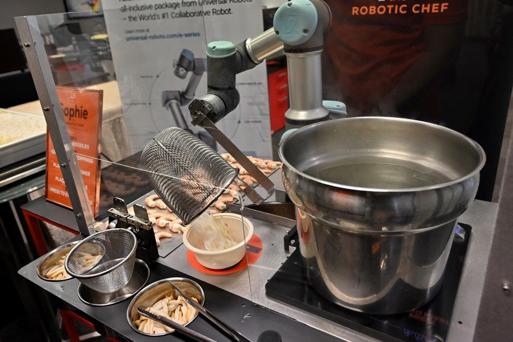 This picture taken on July 26, 2019 shows Sophie the robotic chef preparing to make laksa, a local dish of rice noodles served in a curry sauce, in Singapore. 