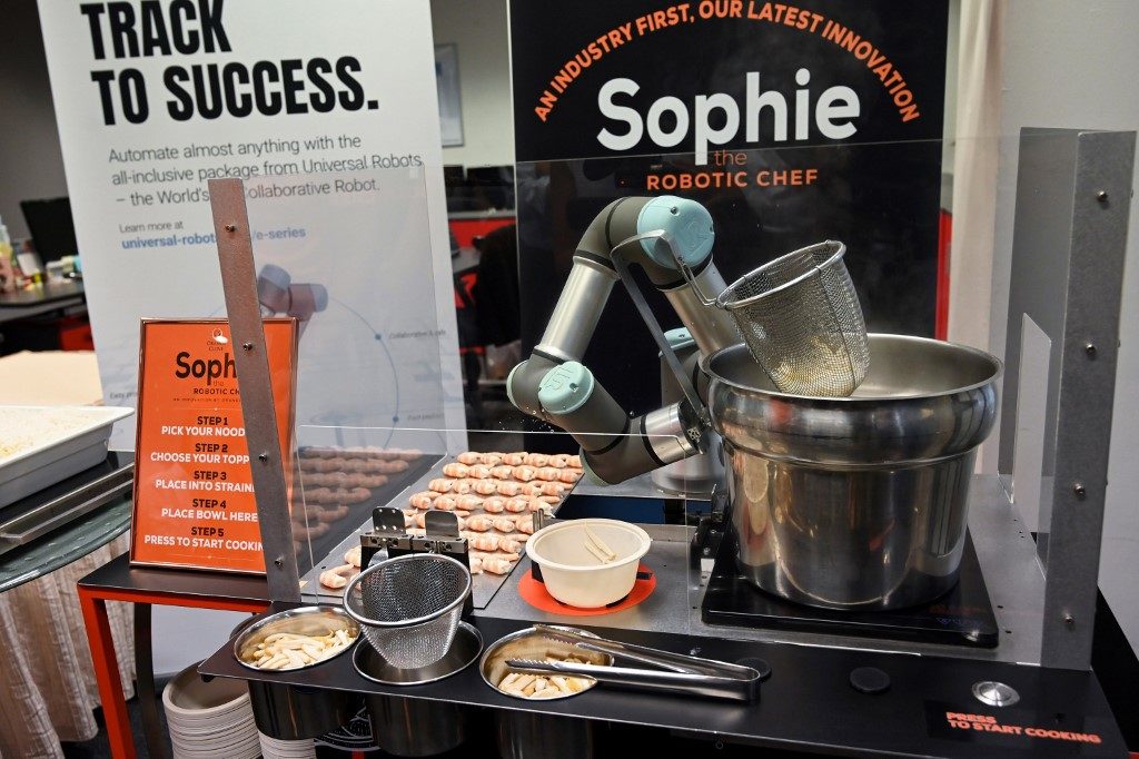This picture taken on July 26, 2019 shows Sophie the robotic chef preparing to make laksa, a local dish of rice noodles served in a curry sauce, in Singapore. - A Singaporean engineering company has built a robot that can serve up a piping hot bowl of laksa, one of the city-state's most well-known dishes, in just 45 seconds. (Photo by Roslan RAHMAN / AFP)