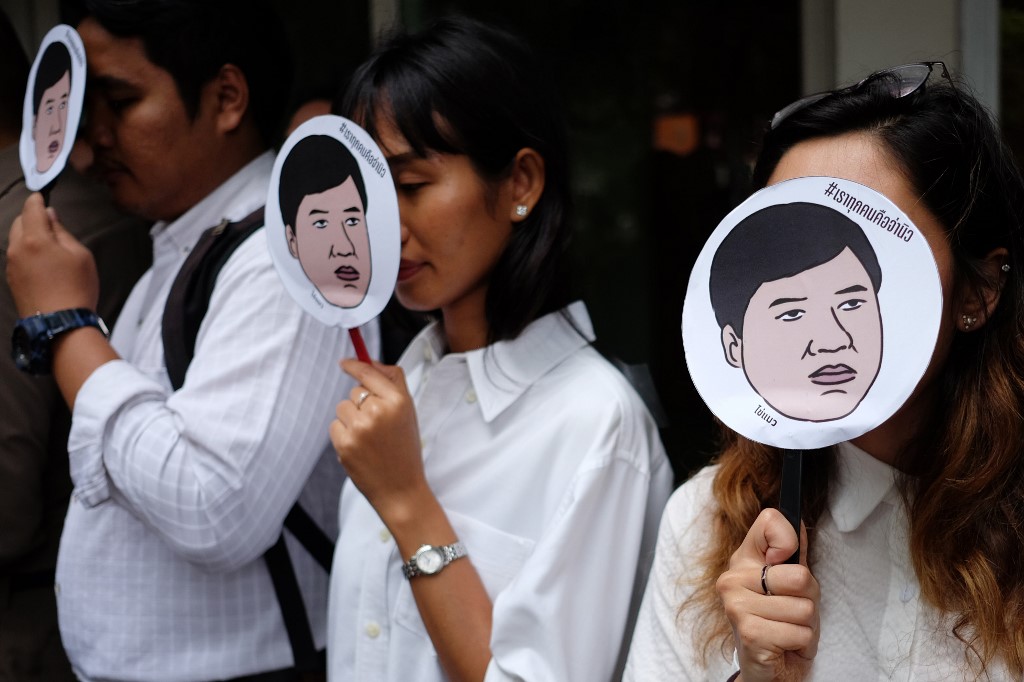 Amnesty International activists hold masks with an image of Sirawith ‘Ja New’ Seritiwat, who was beaten by unknown assailants, reading ‘We are all Ja New’ at a Wednesday protest in Bangkok. Photo: Candida Ng / AFP
