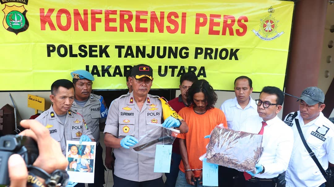 Police showing machete used by Anton Nuryanto (in orange), a North Jakarta resident who slashed his own wife’s throat after she refused to have sex with him. Photo: North Jakarta Police