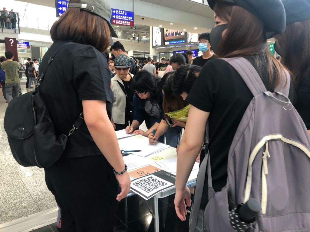 Aviation industry workers line up to sign a petition criticizing the government and police. Photo by Iris To.