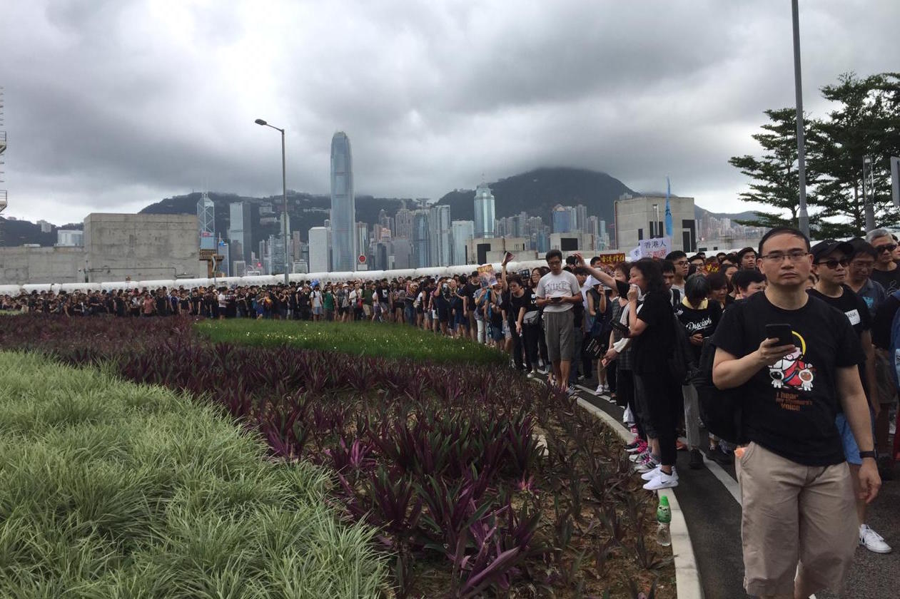 A line of protesters stretches out near the site of Hong Kong’s high-speed rail terminus with mainland China. Hong Kong island looms in the background. Photo by Stuart White/Coconuts Hong Kong