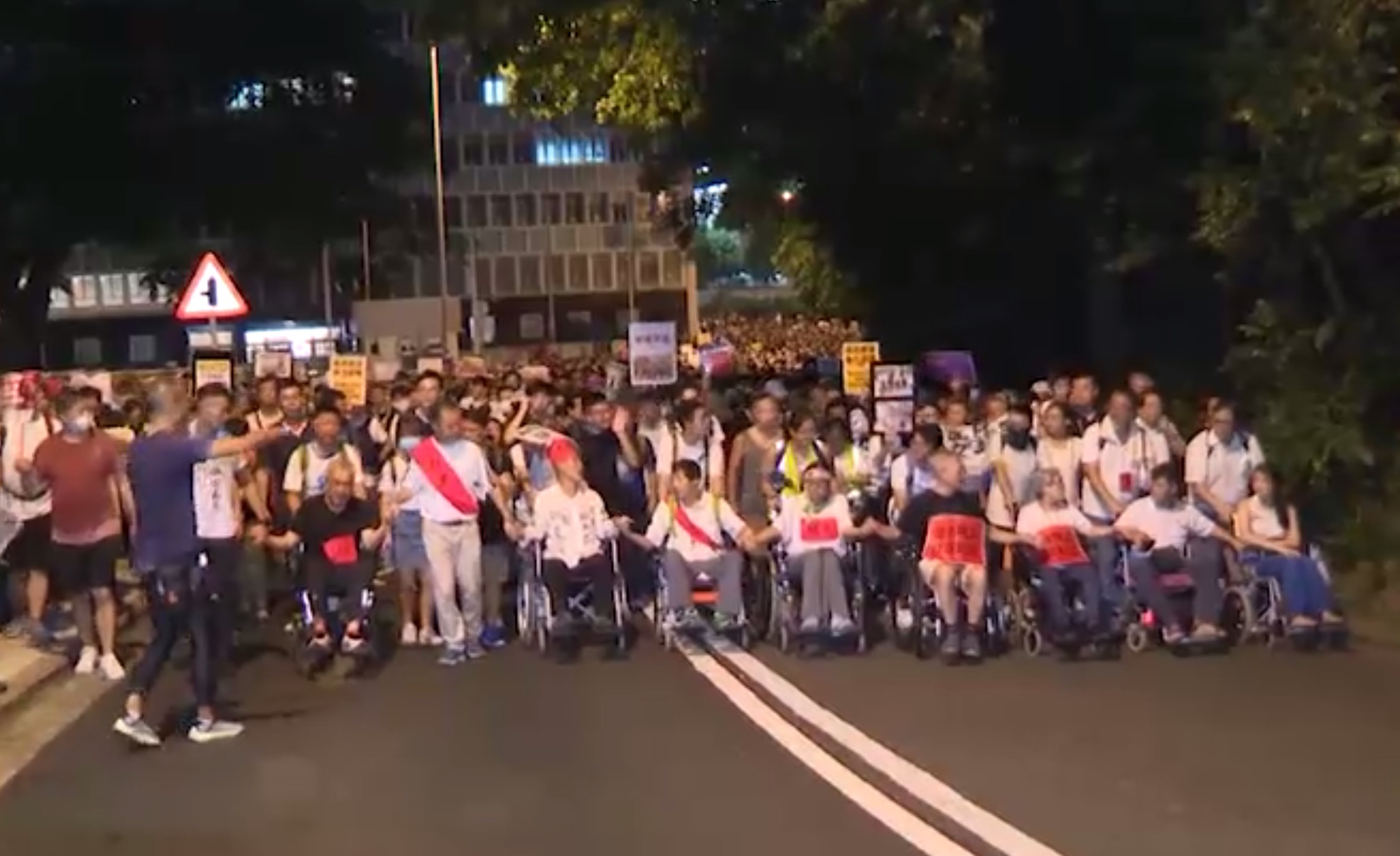 Hunger strikers and other protesters march to the chief executive’s residence last night. Screengrab via RTHK.