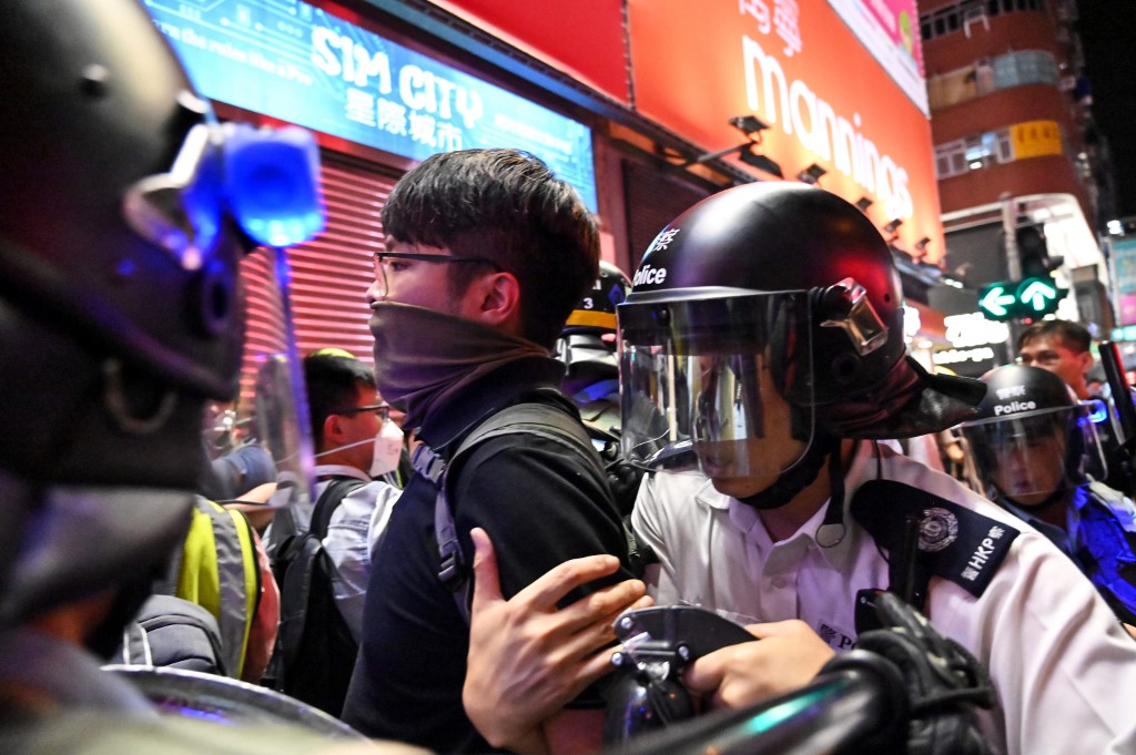 Police arrest a protester during a clash in the Mong Kok district in Kowloon after a march to the West Kowloon rail terminus against the proposed extradition bill in Hong Kong on July 7, 2019. Photo by Hector Retamal/AFP