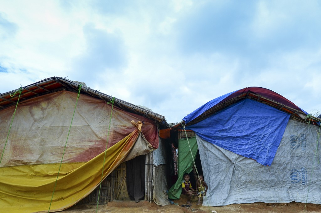 Rohingya children play in front of their makeshift home at Kutupalong refugee camp in Ukhia on July 24, 2019. (Photo by Munir Uz Zaman / AFP)