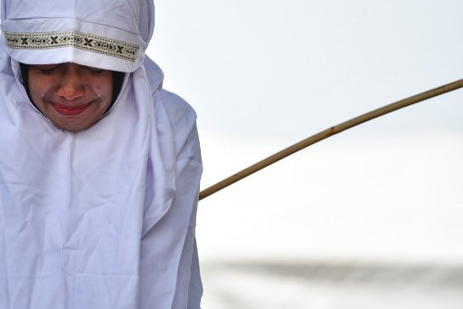 FILE PHOTO: A woman is whipped in public in Banda Aceh in Indonesia’s staunchly conservative Aceh province on August 1, 2019, as punishment for being too close to the opposite sex. (Photo by CHAIDEER MAHYUDDIN / AFP)
