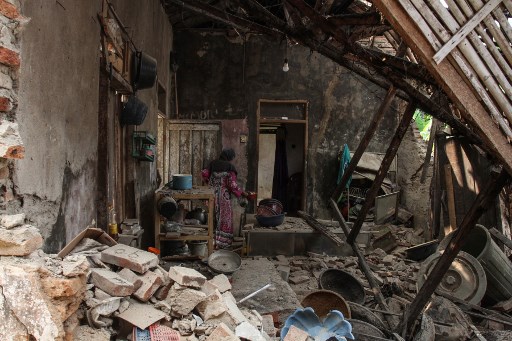 A villager looks for her belongings at her damage house in Pandeglang, Banten province on August 3, 2019, after a strong earthquake hit the area. – Indonesian authorities lifted a tsunami warning after a powerful 6.9 magnitude earthquake earlier struck off the southern coast of heavily populated Java island. (Photo by SAMMY / AFP)