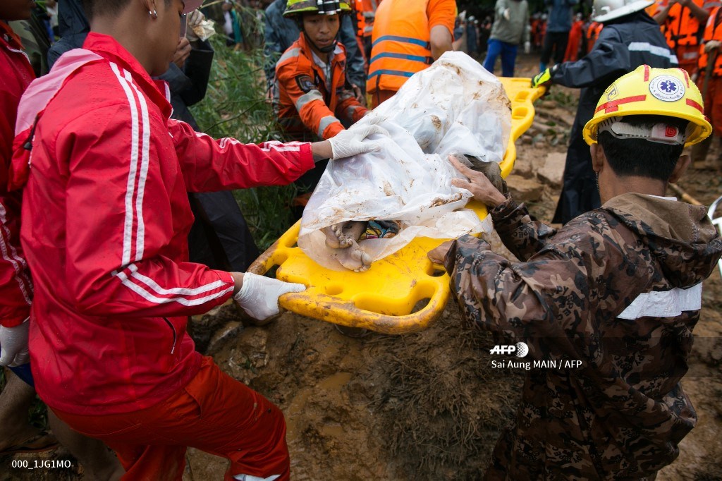 Rescue workers carry the body of a landslide victim in Paung township, Mon state on August 10, 2019.(Photo by Sai Aung MAIN / AFP)