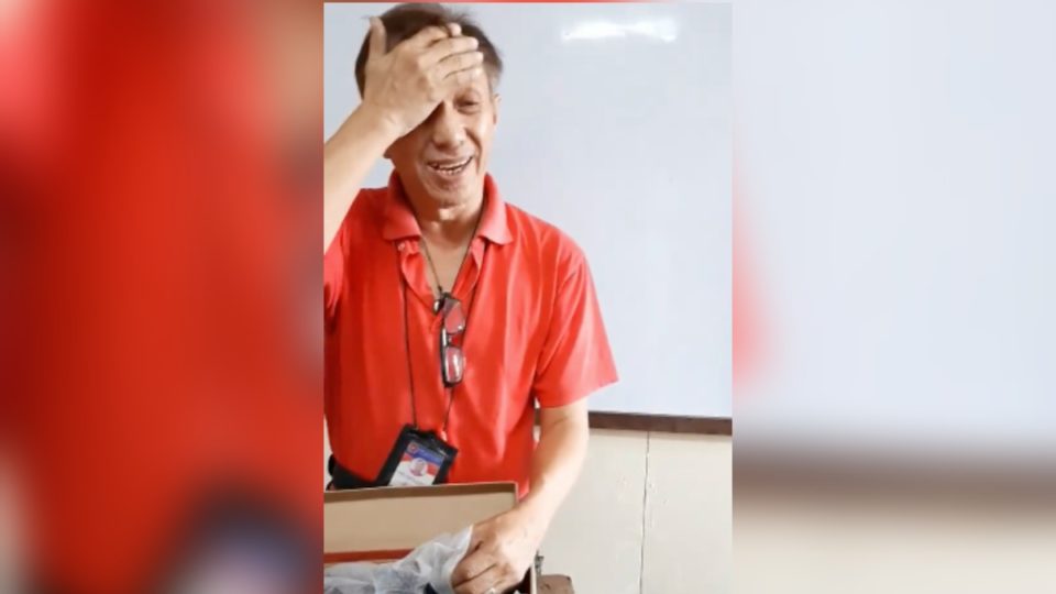 Science teacher Cesar Punzalan with the pair of shoes he received from his students. <i></noscript>Photo: Screenshot from Mary Anne Claire Garcia</i>