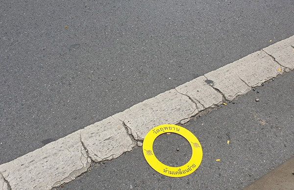 One of over a dozen ball bearings marked by investigators in Narathiwat Rajanagarindra Road on Friday morning. Photo: Coconuts