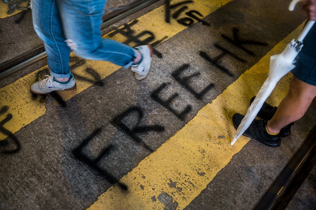 Protesters build barricades to block the road in the busy shopping district of Causeway Bay in Hong Kong on August 4, 2019, in the latest opposition to a planned extradition law that has quickly evolved into a wider movement for democratic reforms. Isaac Lawrence / AFP