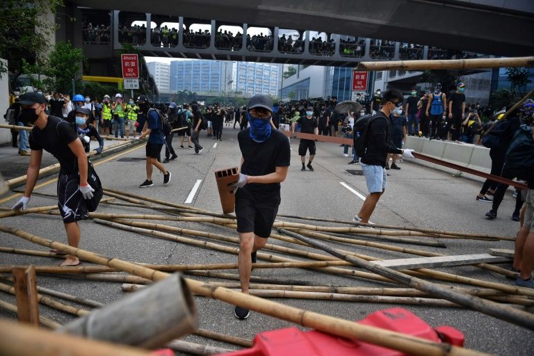 Protesters build barriers as they block a road in Hong Kong’s Kowloon Bay on August 24, 2019. Photo: Lillian SUWANRUMPHA / AFP