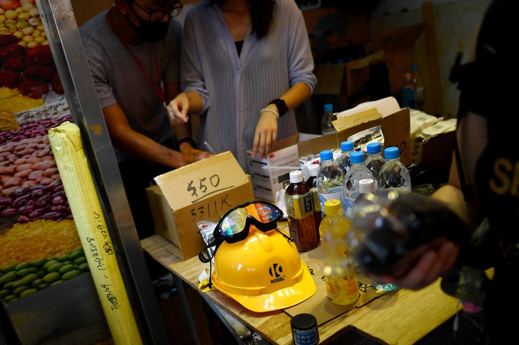 This picture taken on August 10 show pro-democracy protesters buying gas masks and other protective gear at a pop-up store in Tai Po. Photo via AFP.