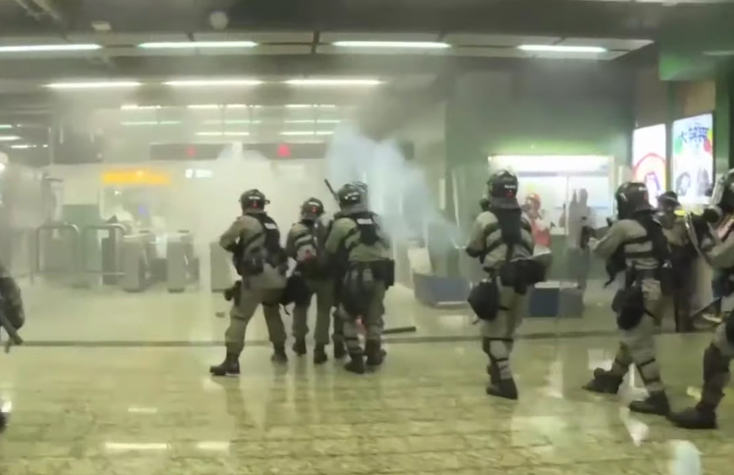 Riot cops fire tear gas into the paid concourse area of Kwai Fong MTR station on the night of August 11. Screengrab via YouTube.