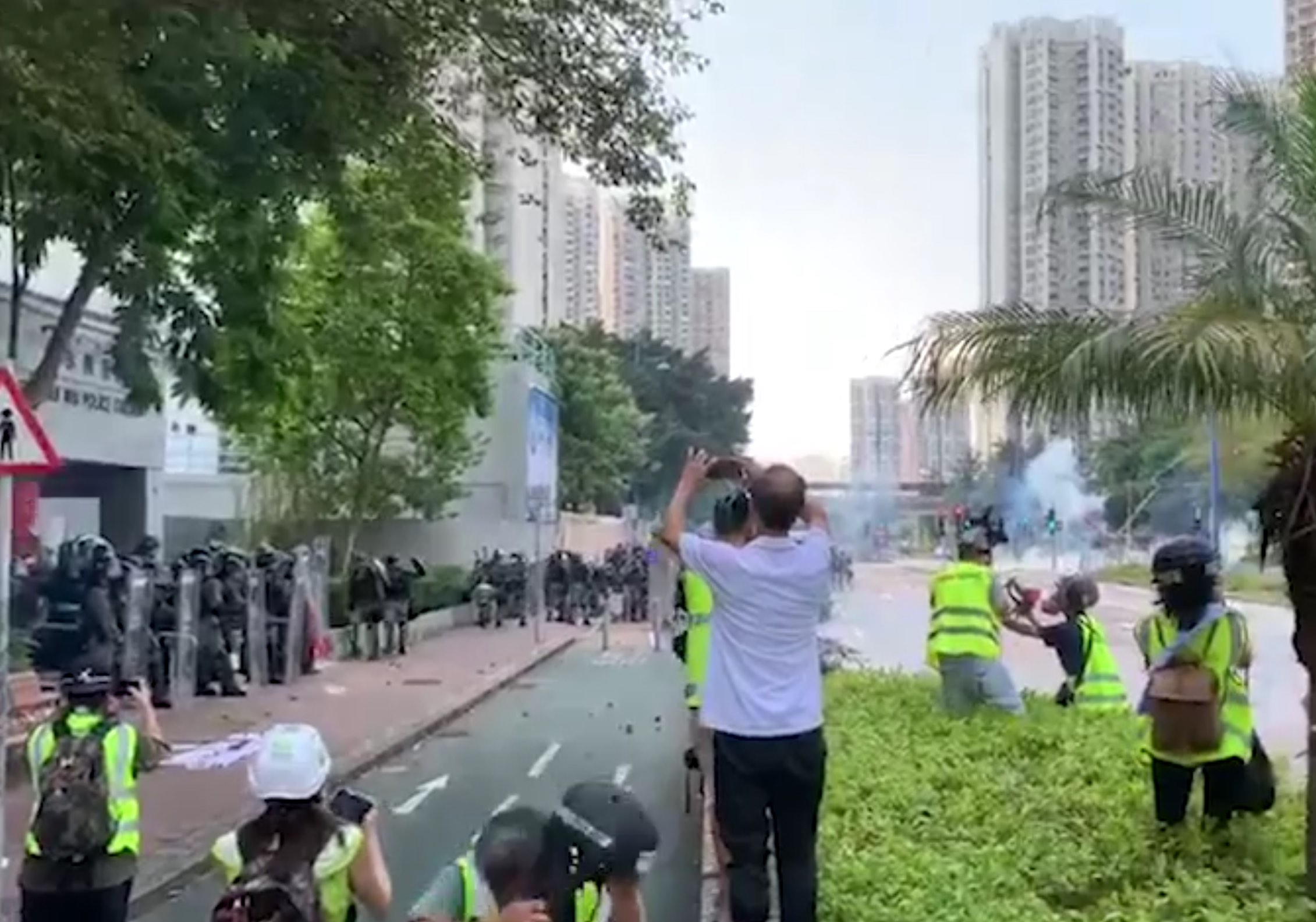Police fire tear gas at a crowd of stone-throwing protesters outside the Tin Shui Wai police station this afternoon. Screengrab via RTHK video.
