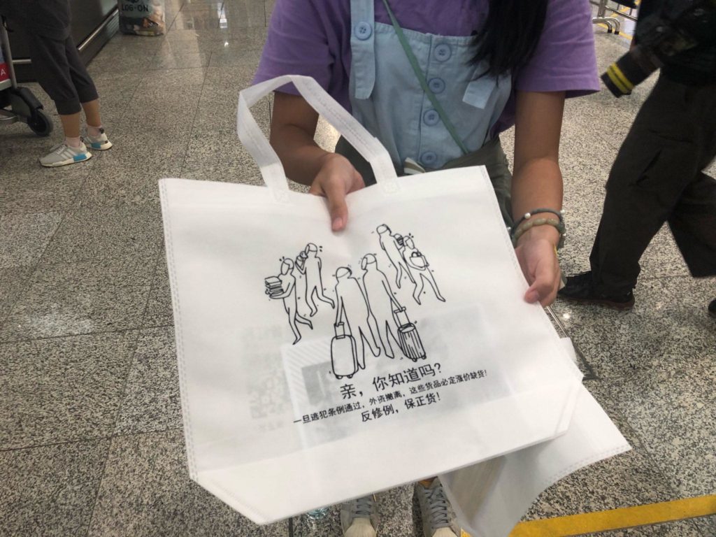 A tote warning mainland tourists of higher prices should investment flee Hong Kong. Photo by Iris To.