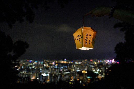 A woman holds a paper lantern as she takes part in forming a human chain with other pro-democracy activists on Lion Rock in Hong Kong on September 13, 2019. – Thousands of Hong Kong pro-democracy activists used torches, lanterns and laser pens to light up two of the city’s best-known hillsides on September 13 night in an eye-catching protest alongside an annual festival. The evening of September 13 marks the start of the mid-autumn festival, one of the most important dates in the Chinese calendar, and is traditionally a time for thanksgiving, spending time with family and praying for good fortune. (Photo by Anthony WALLACE / AFP)