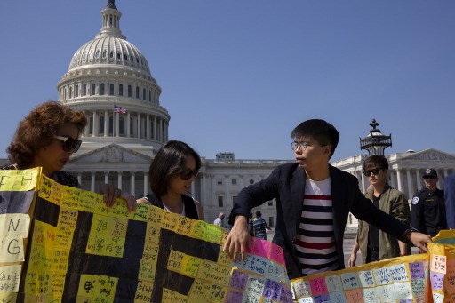 Hong Kong pro-democracy activist Joshua Wong (R) and other activists unfurl a banner containing messages, written during a rally outside the US consulate in Hong Kong on September 8, in front of the US Capitol in Washington, DC, on September 21, 2019. (Photo by Alastair Pike / AFP)