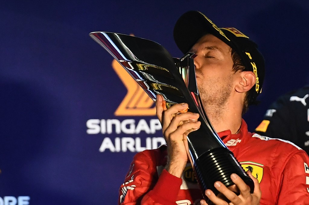Ferrari’s German driver Sebastian Vettel kisses the trophy on the podium after winning the Formula One Singapore Grand Prix night race at the Marina Bay Street Circuit in Singapore on September 22, 2019. (Photo by Mohd RASFAN / AFP)