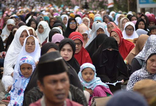 Survivors of the 2018 earthquake-triggered tsunami attend a mass prayer to commemorate the disaster in Palu, Central Sulawesi, on September 28, 2019. – Thousands attended a mass prayer in the devastated Indonesian city of Palu on September 28, one year after a quake-tsunami swallowed up whole neighbourhoods and killed more than 4,000 people. (Photo by OLAGONDRONK / AFP)