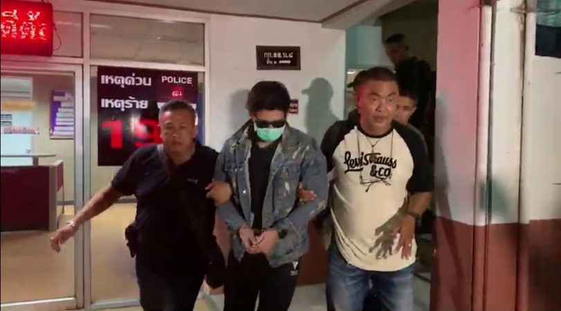 Police escort Rachadech Wongthabutr on Tuesday night in Bangkok. Photo: Police News