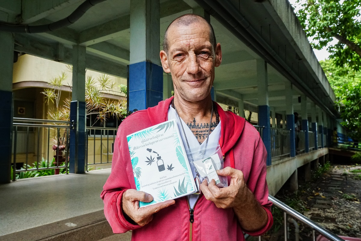 Philippe Gobert poses with a medical marijuana patient guide and a bottle of sublingual cannabis oil. Photo: Coconuts Bangkok 