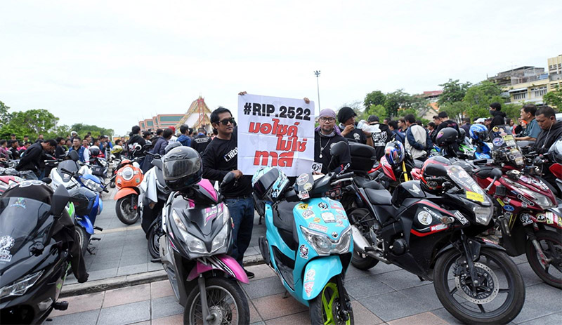 ‘Motorcyclists aren’t slaves,’ reads a man’s sign Sunday outside City Hall where hundreds rallied to protest a ban on riders’ use of bridges and tunnels. Photo: Bangkok Metropolitan Administration