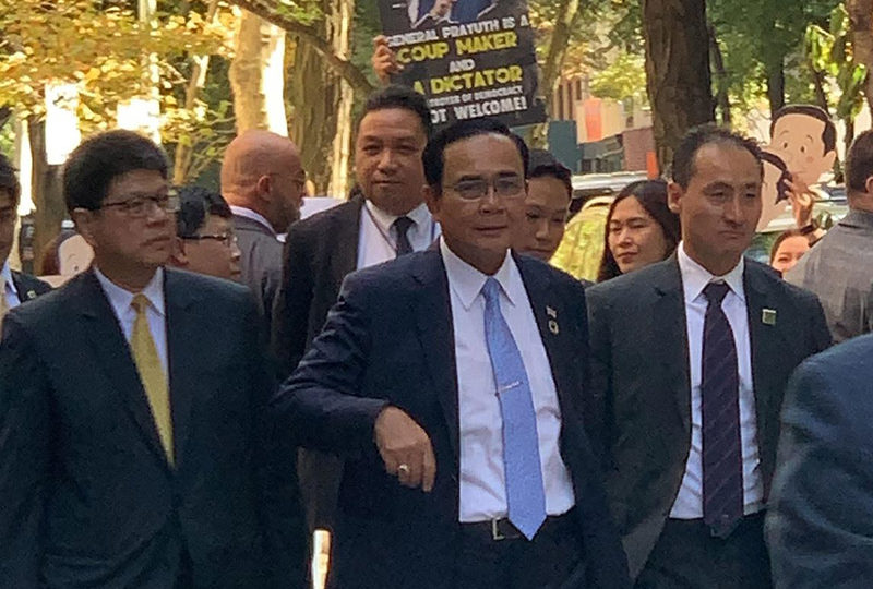 ‘General Prayuth is a coup maker and a dictator,’ reads a sign held Wednesday behind Thai Prime Minister Prayuth Chan-o-cha in New York.