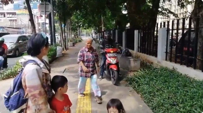A motorcyclist driving on the sidewalk in Jakarta. Photo: Video screengrab