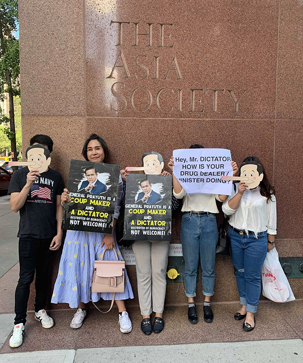 Protesters including exiled dissident Nachacha Kongudom, second from left, post outside the Asia Society in New York.
