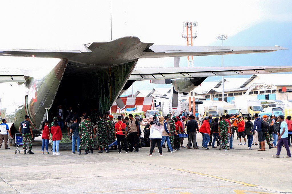 (FILES) In this file photo taken on September 30, 2019 Indonesian military assist residents evacuated from Wamena as they arrive at an airport in Jayapura, after violence broke out again in Indonesia’s Papua. – More than 16,000 scared residents have fled an unrest-hit city in Indonesia’s Papua region, the military said on October 7, 2019, as one of the deadliest eruptions of violence in years sparked calls for an independent probe. (Photo by Indra Thamrin Hatta / AFP)