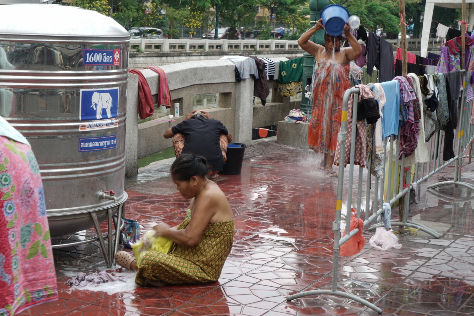 Citizens bathe and do laundry with fresh water tanks prepared for them. Photo: Coconuts