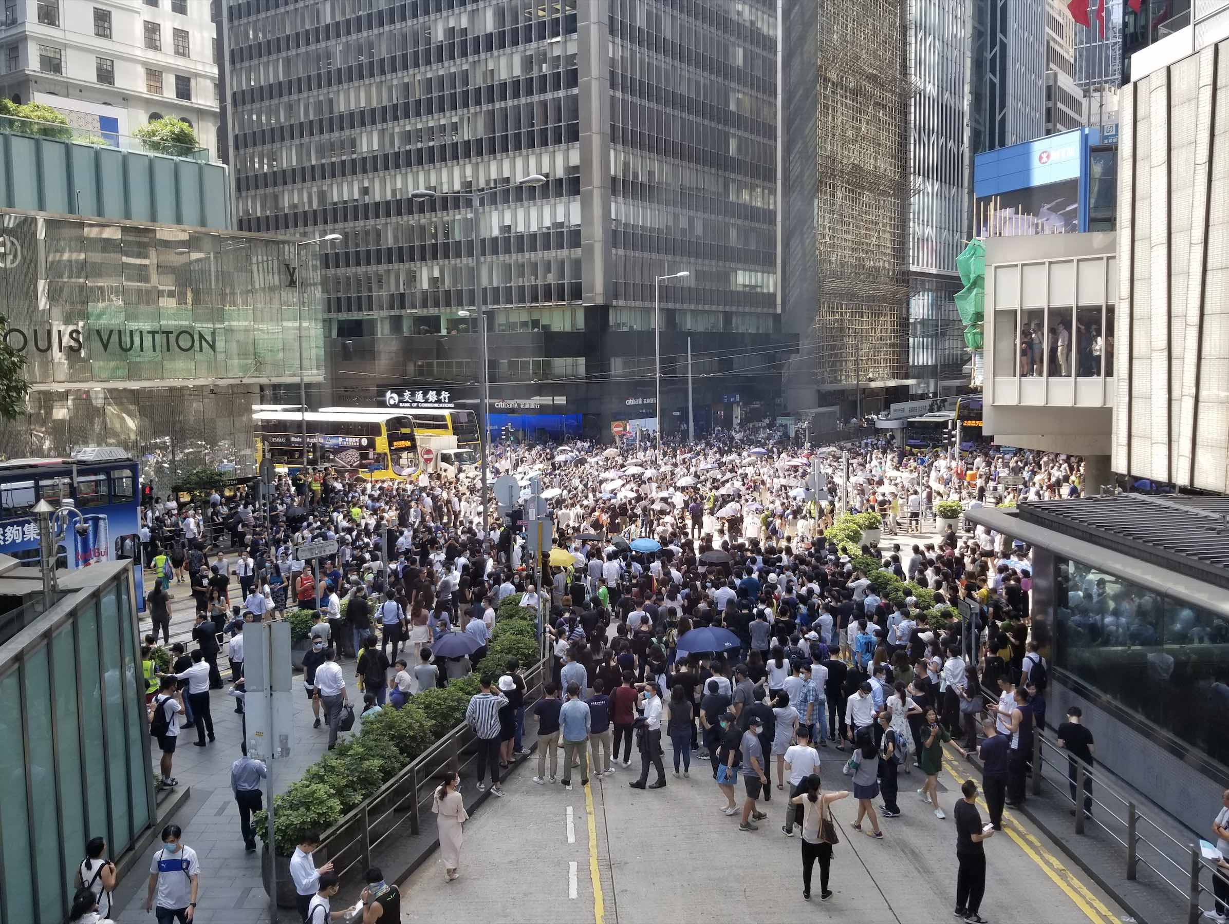 Hundreds block traffic at an intersection in Central to protest government plans to introduce an anti-mask law. Photo by Vicky Wong.