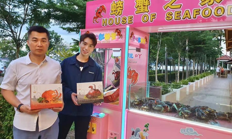 House of Seafood CEO Francis Ng, at left, with minor celeb Lawrence Hiew at Friday’s relaunch of the much-maligned crab machine, this time with empty box instead of live crabs. Those who successfully catch a box can exchange it for a cooked crab. Photo: Lawrence Hiew / FB