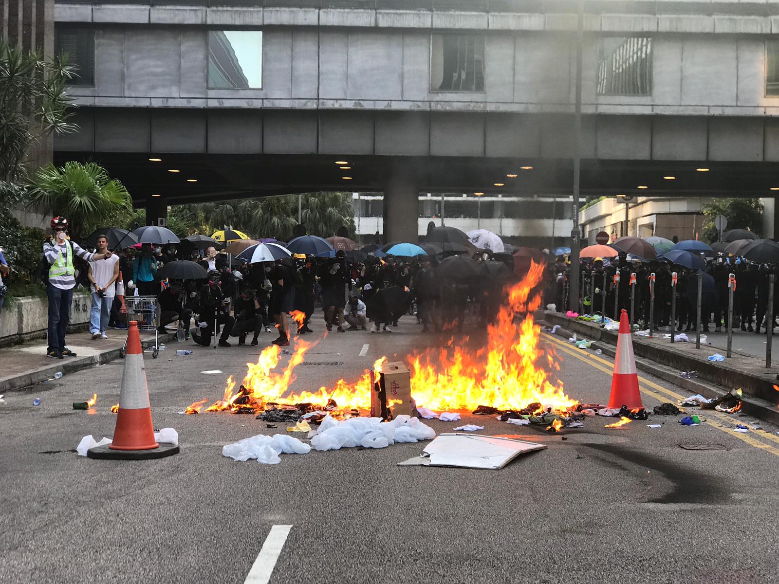 A fire burns on a street in the vicinity of the government office complex in Admiralty this afternoon as unsanctioned protests cropped up across the city. Photo by Samantha Mei Topp.