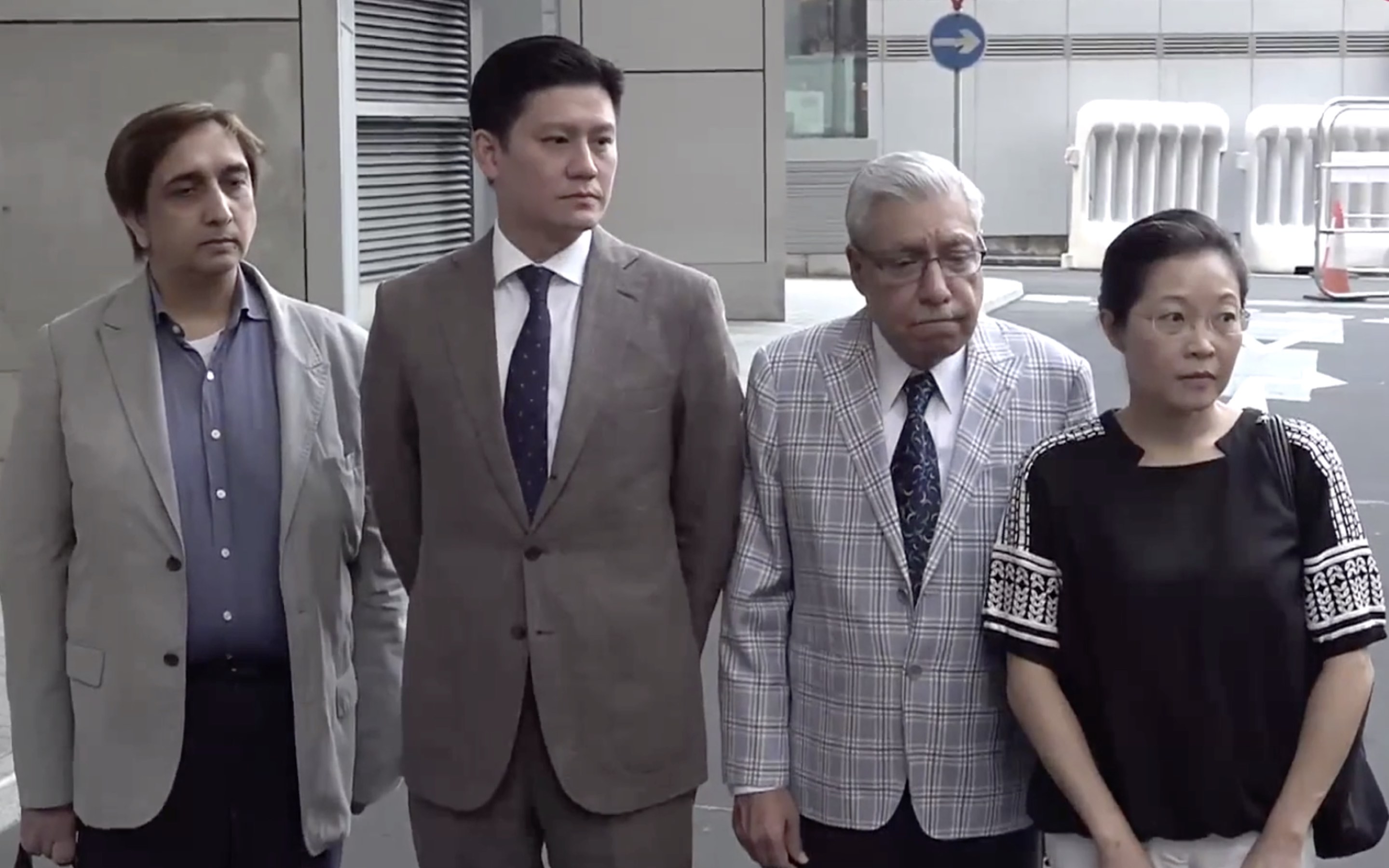 (From left to right) Philip Khan, Jeremy Tam, Mohan Chugani, and Phyllis Cheung arrive outside Police Headquarters in Wan Chai to file a formal complaint against the police use of a water cannon against the. The four were among a small group of people, mostly journalists, who were standing outside a mosque, and no other protesters were in the area. Screengrab via Apple Daily video.