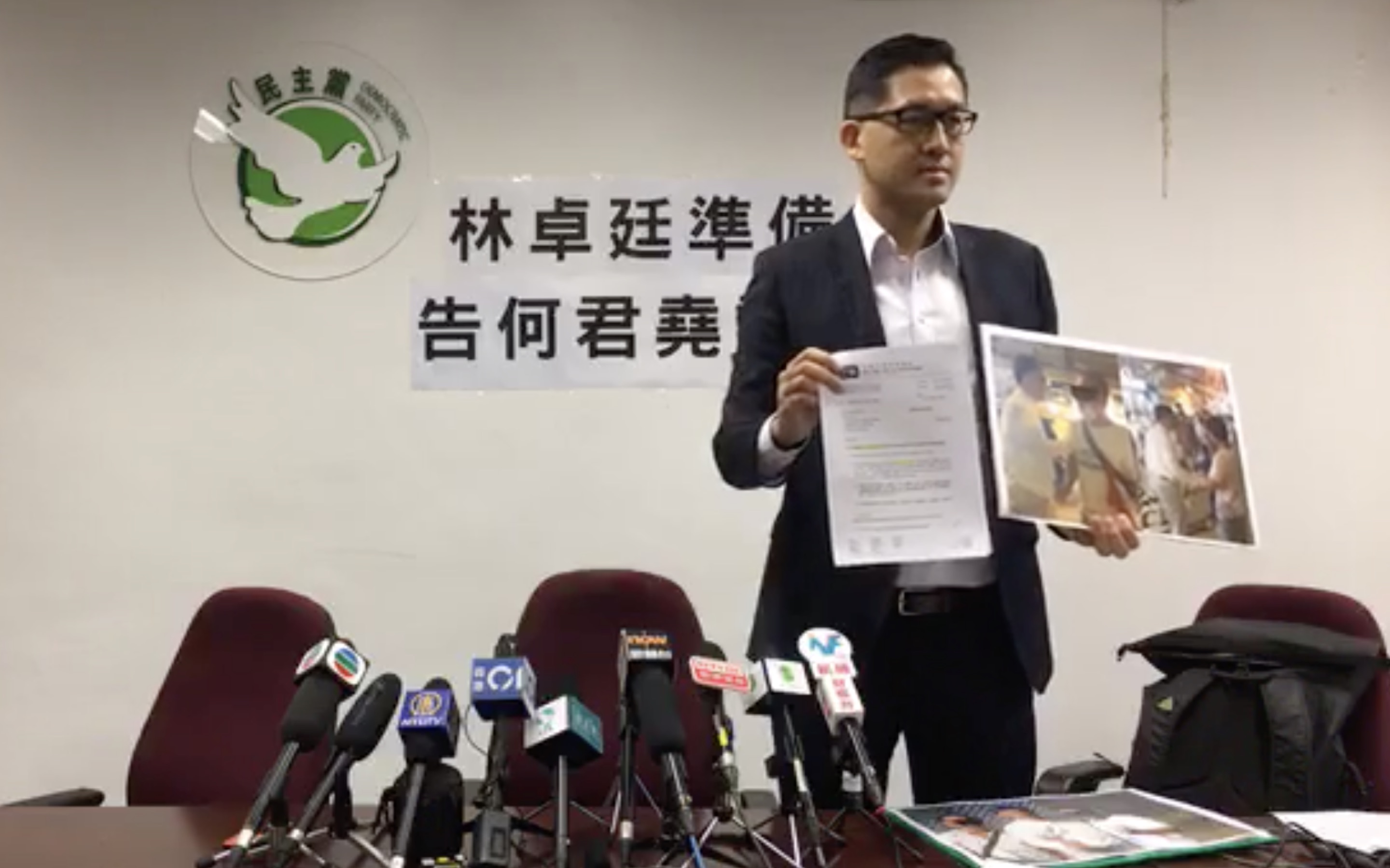 Lam Cheuk-ting holds up a copy of a legal letter confirming he’s suing pro-Beijing lawmker Junius Ho for defamation. Screengrab via Facebook video/Lam Cheuk-ting.