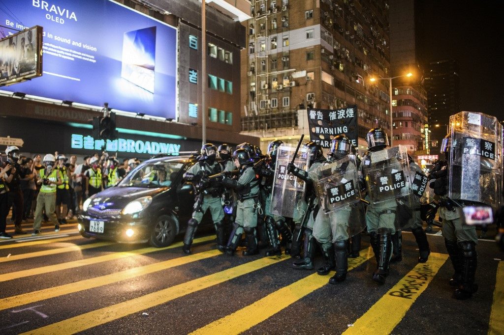 Police prepare to fire tear gas towards residents and protesters from a pedestrian crossing in the Mong Kok district of Kowloon in Hong Kong on Oct. 27, 2019. Photo via AFP.