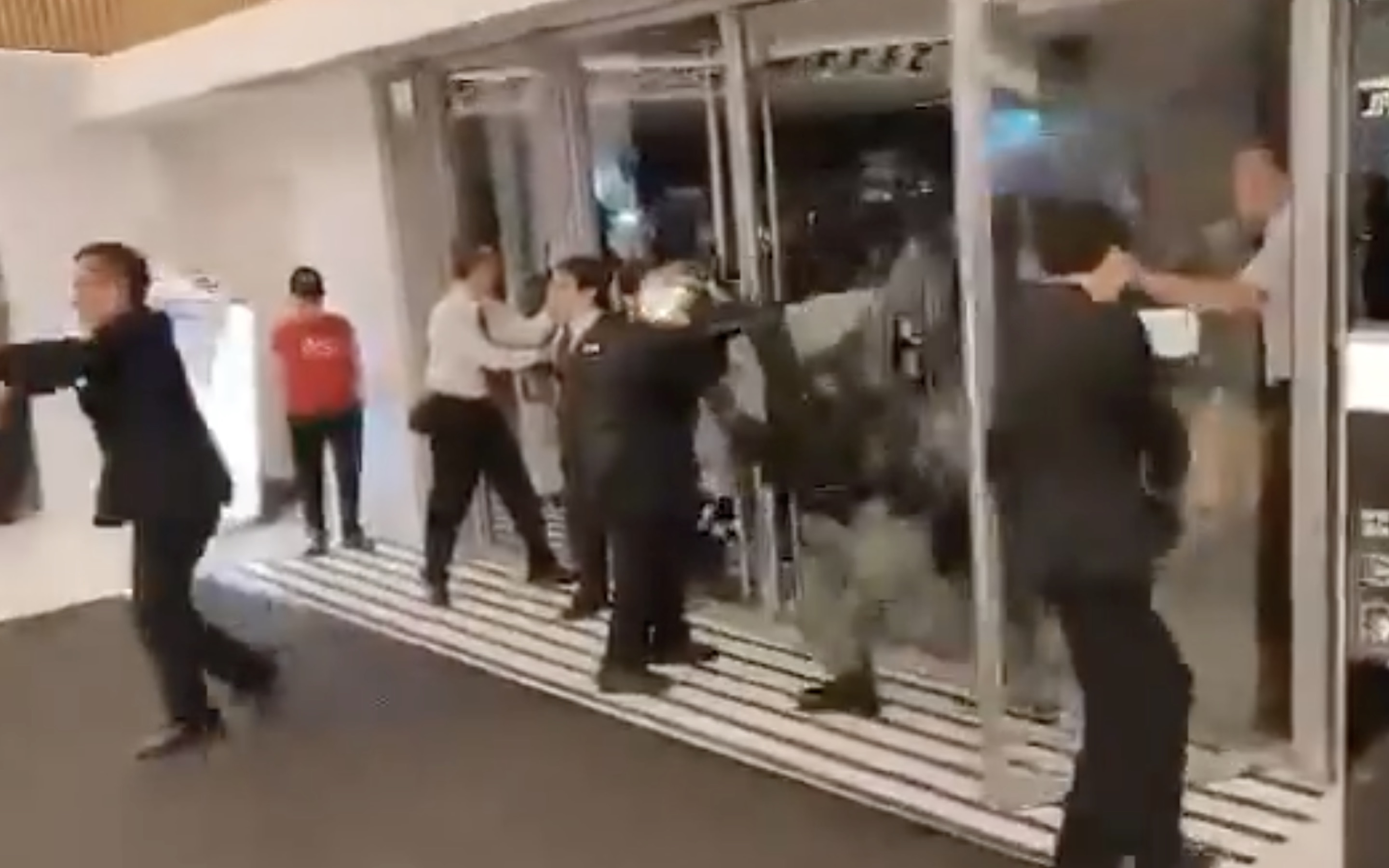 Viral video shows the moment riot police charge into a mall in Ma On Shan to arrest someone. Mall security guards can be seen trying to hold the doors closed to prevent them from entering. Screengrab via Facebook video.