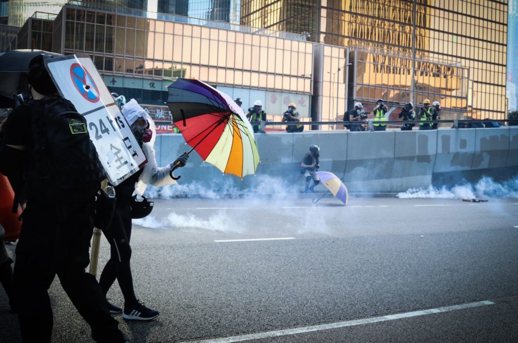 Protesters shield themselves against water cannons and tear gas in Admiralty on October 1, 2019. . Photo via Samantha Mei Topp.