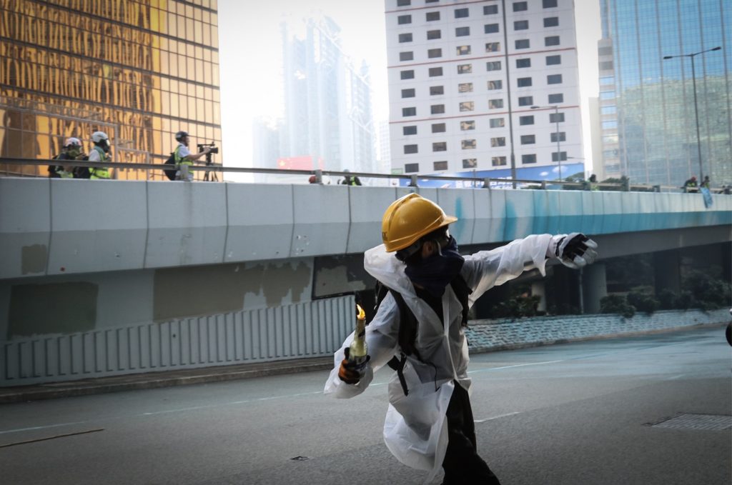 A protester throws a molotov cocktail after police deployed water cannons outside the Chief Executive's office in Admiralty on Tuesday. Photo by Samantha Mei Topp.