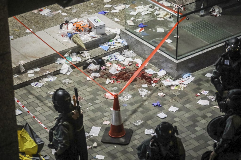 Blood and debris are seen on the ground at the entrance of a shopping mall after a bloody knife fight broke out in Hong Kong on November 3, 2019. – A bloody knife fight in Hong Kong left six people wounded on November 3 evening, including a local pro-democracy politician who had his ear bitten off, capping another chaotic day of political unrest in the city. (Photo by VIVEK PRAKASH / AFP)