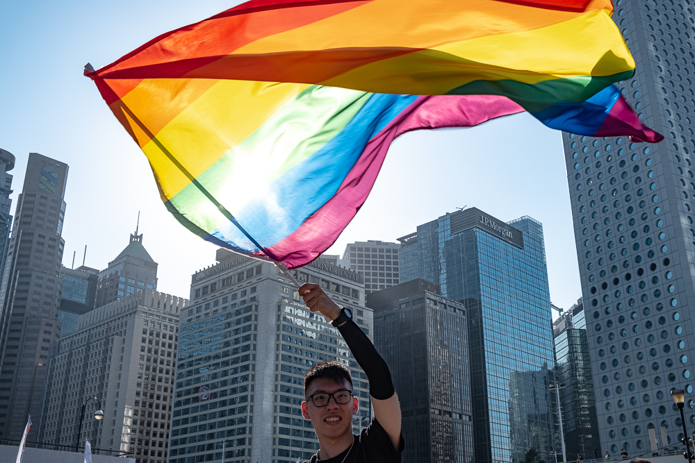 Man waves rainbow flag at the Hong Kong 2019 pride gathering. Photo by Tomas Wiik.