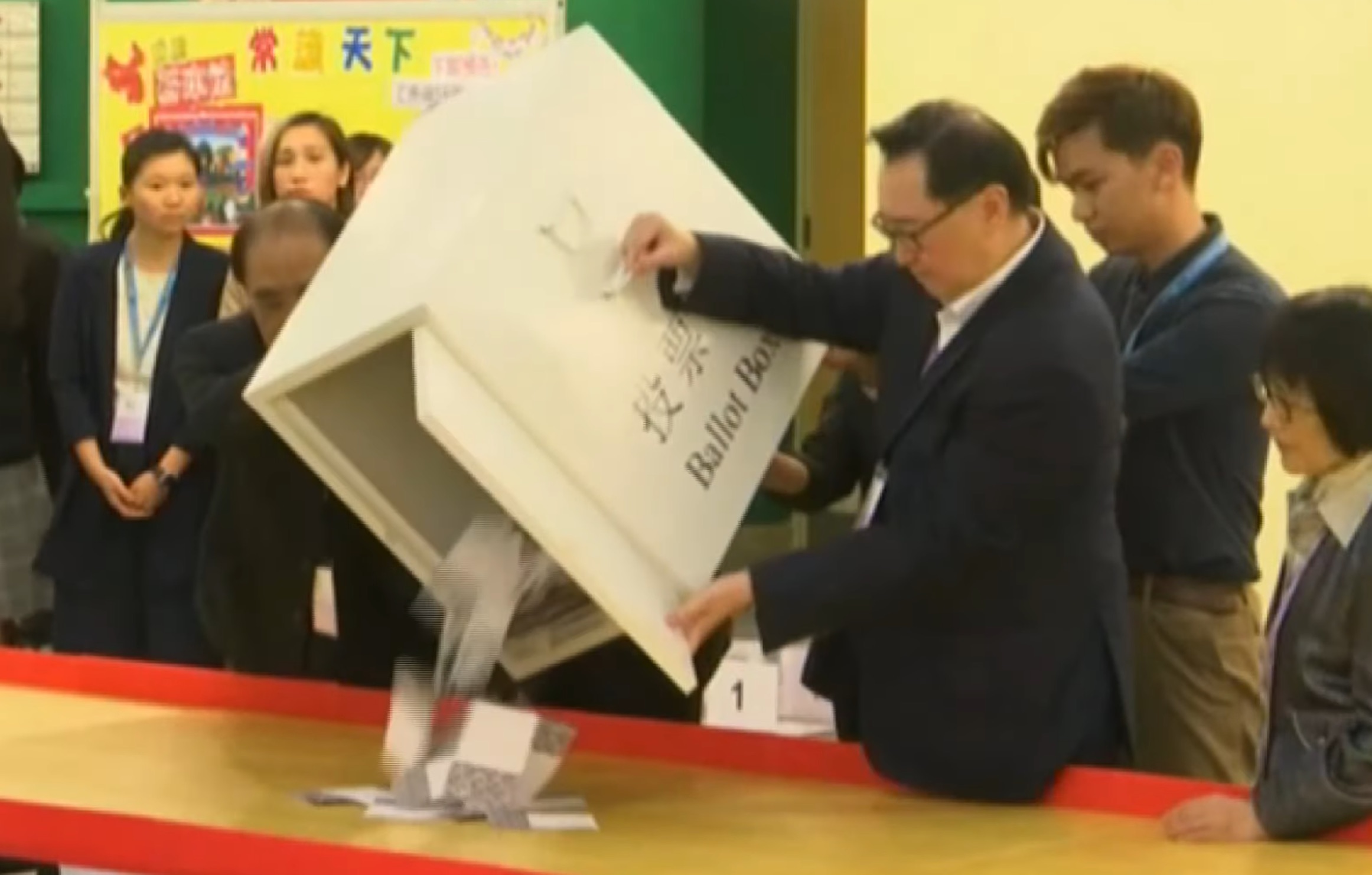 Election officials empty ballots onto a table as counting in Hong Kong’s district council elections gets underway last night. Screengrab via YouTube.