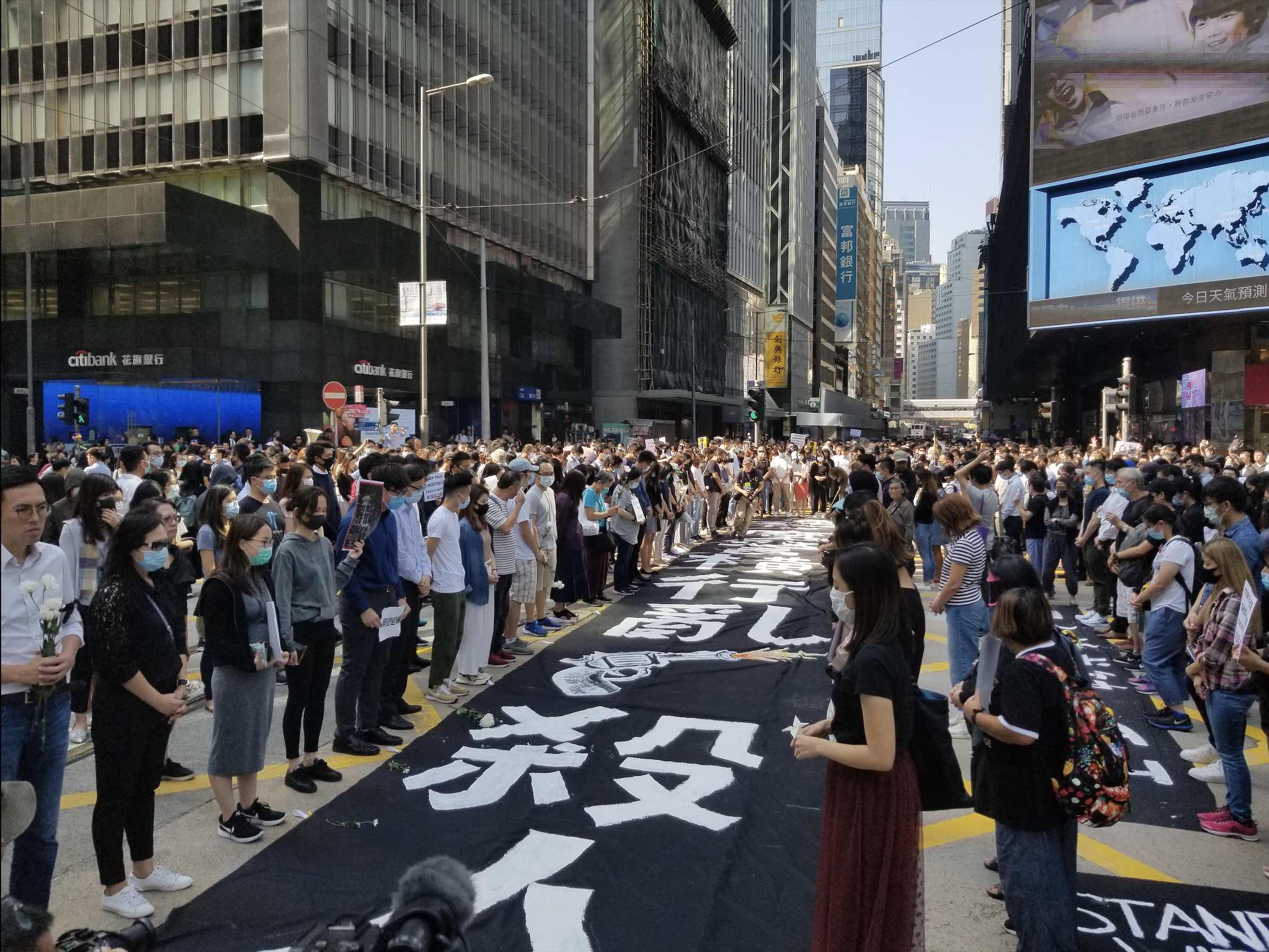 Hundreds have a moment of silence for 22-year-old Chow Tsz-lok, the student who died days after falling from a height at a car park in Tseung Kwan O. Photo by Vicky Wong.