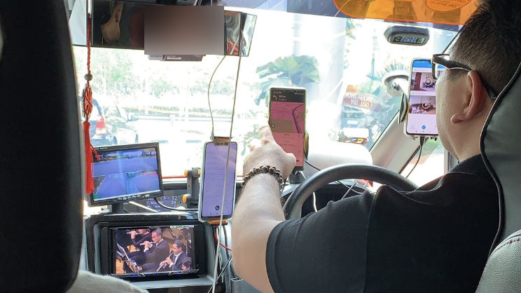 Grab driver with five screens fixed in front of him. Photo: @HarvinthSkin/Twitter