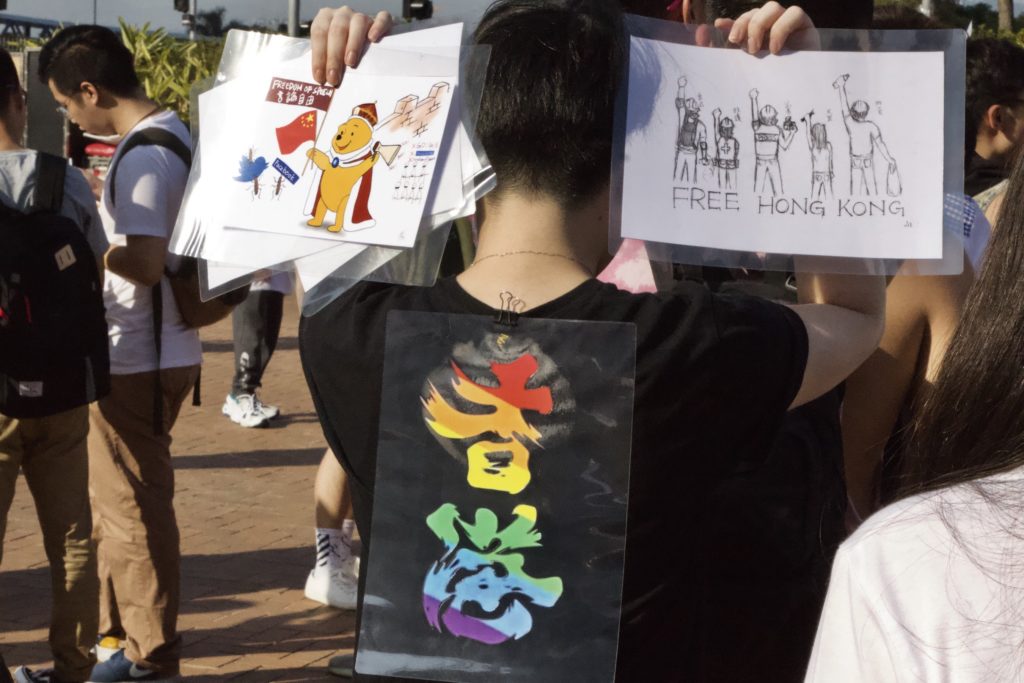 Person holds anti-government placards at Hong Kong Pride 2019. Photo by Vicky Wong.