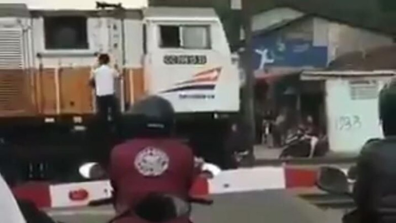 An Indonesian machinist boarding a train after he bought some snacks. Photo: Video screengrab